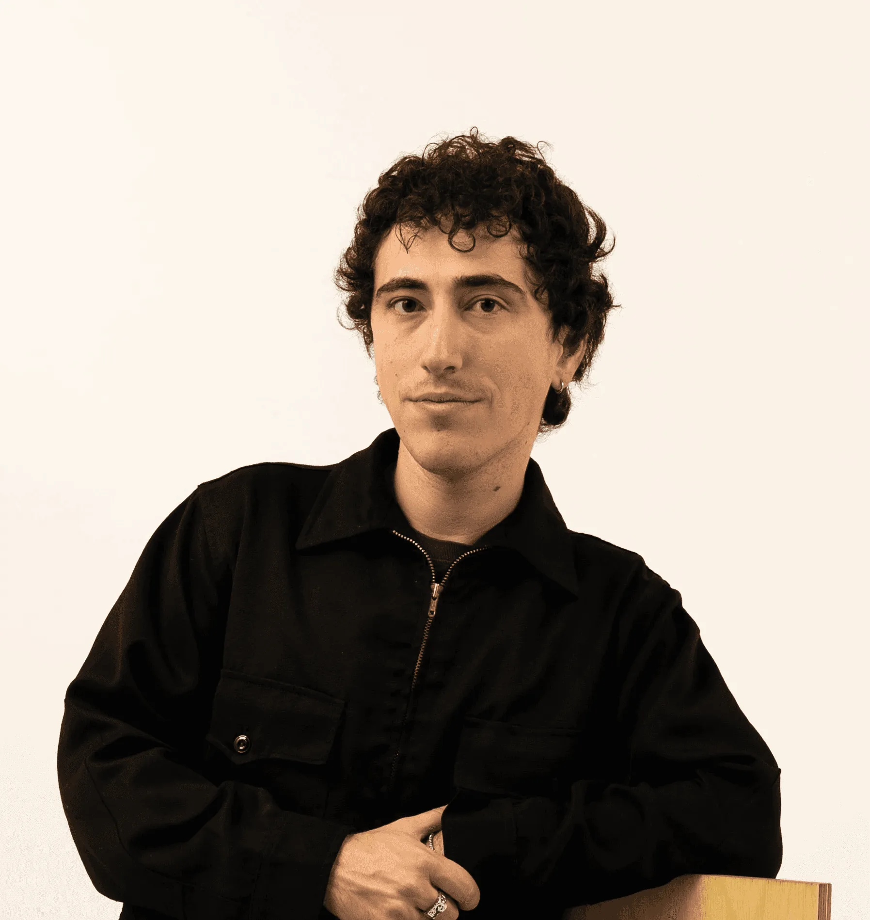 Cole S, 3D Arts Instructor, with curly hair in a black jacket